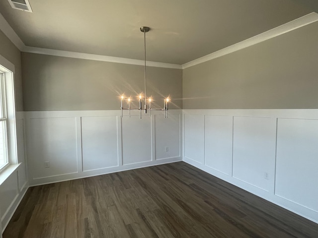 unfurnished dining area with an inviting chandelier, crown molding, and dark wood-type flooring