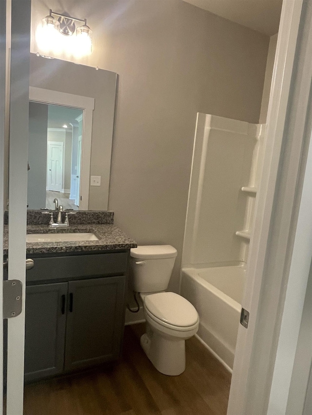 full bathroom featuring shower / tub combination, vanity, hardwood / wood-style floors, and toilet