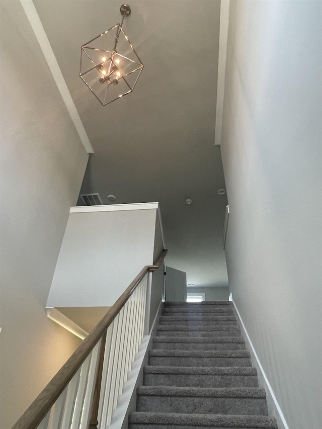 stairway featuring a chandelier