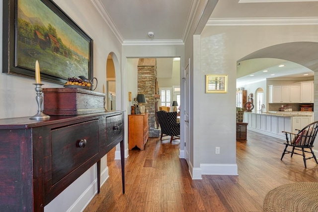 corridor featuring crown molding, wood-type flooring, and sink