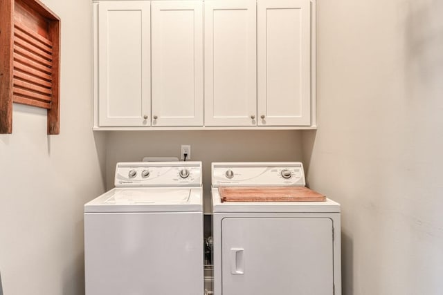 washroom featuring separate washer and dryer and cabinets