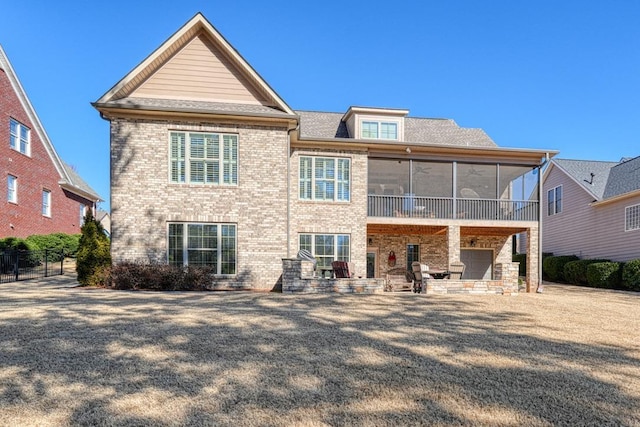 rear view of house featuring a patio area and a sunroom