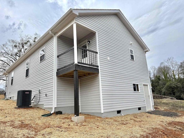 view of side of property featuring a balcony and central air condition unit