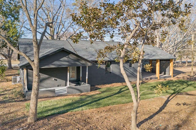 view of front of house with a front yard and central air condition unit