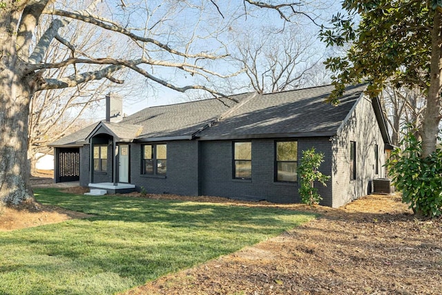 view of front of home with a front yard and central air condition unit