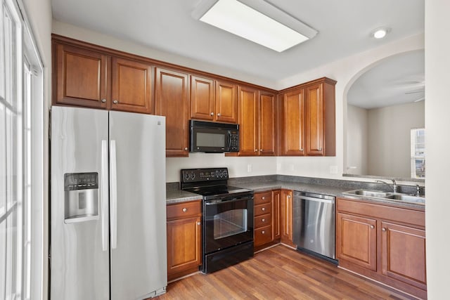 kitchen with sink, dark wood-type flooring, and black appliances