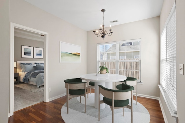 dining area with an inviting chandelier and dark hardwood / wood-style flooring