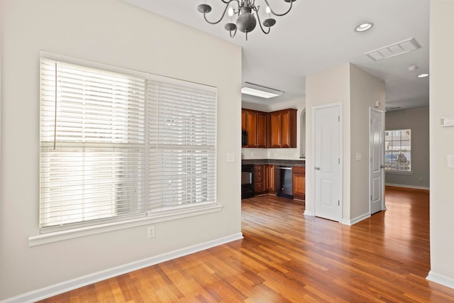 unfurnished living room featuring hardwood / wood-style floors and a chandelier