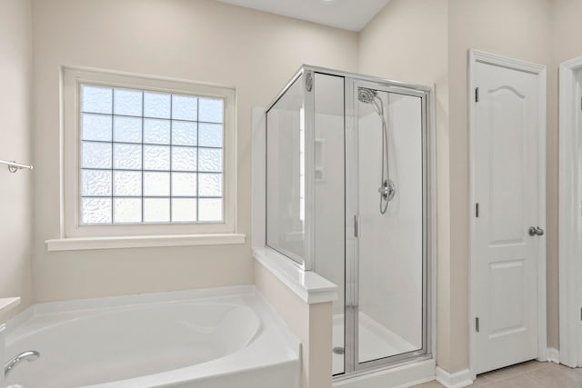 bathroom with independent shower and bath and tile patterned flooring