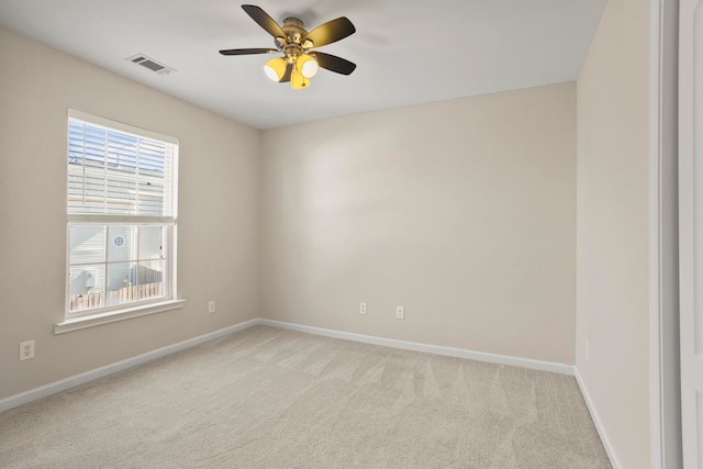 spare room featuring light carpet and ceiling fan