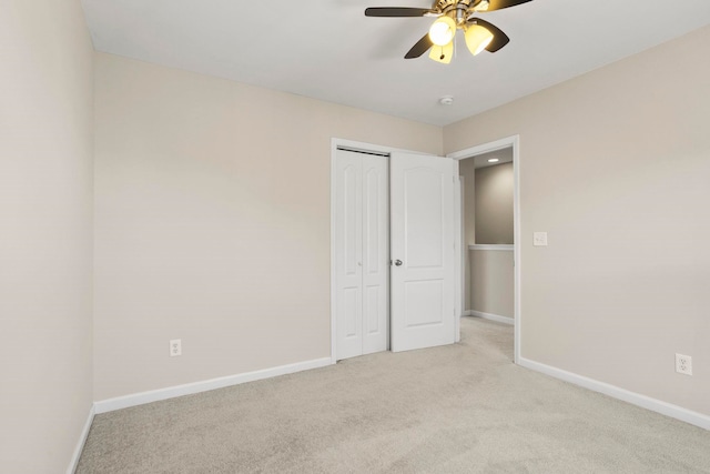 unfurnished bedroom with light carpet, ceiling fan, and a closet