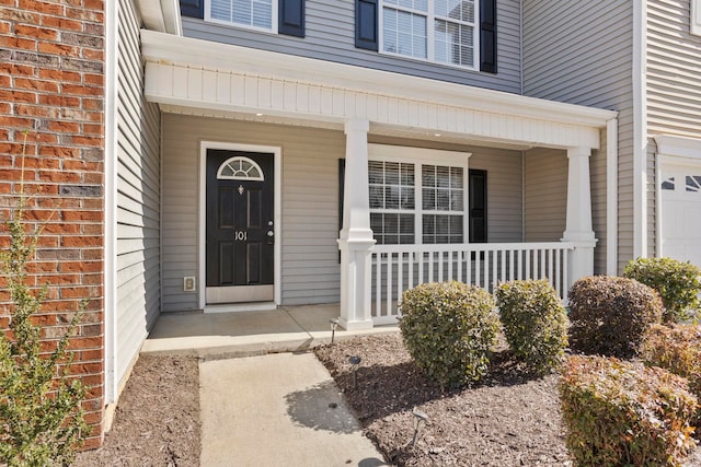 entrance to property featuring a garage and a porch