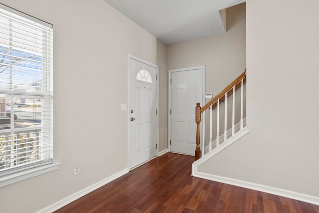 foyer entrance with dark wood-type flooring and a wealth of natural light