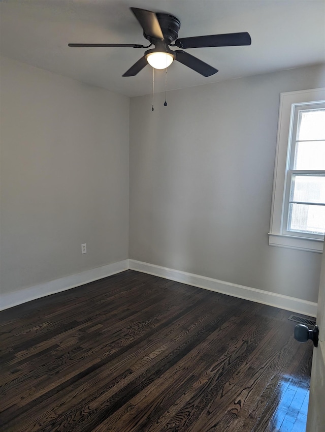 empty room featuring dark wood-type flooring and ceiling fan