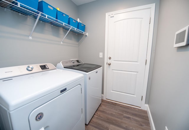 clothes washing area featuring dark hardwood / wood-style flooring and washing machine and dryer