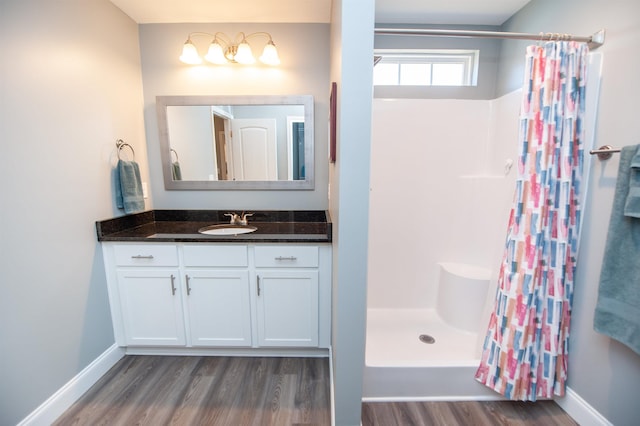 bathroom featuring walk in shower, vanity, and hardwood / wood-style flooring