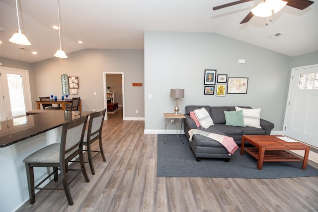 living room featuring vaulted ceiling, ceiling fan, and light hardwood / wood-style floors