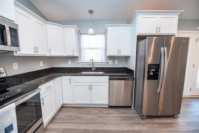 kitchen with white cabinetry, sink, stainless steel appliances, and hanging light fixtures