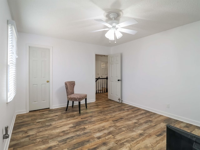 sitting room with ceiling fan, dark hardwood / wood-style flooring, and a textured ceiling