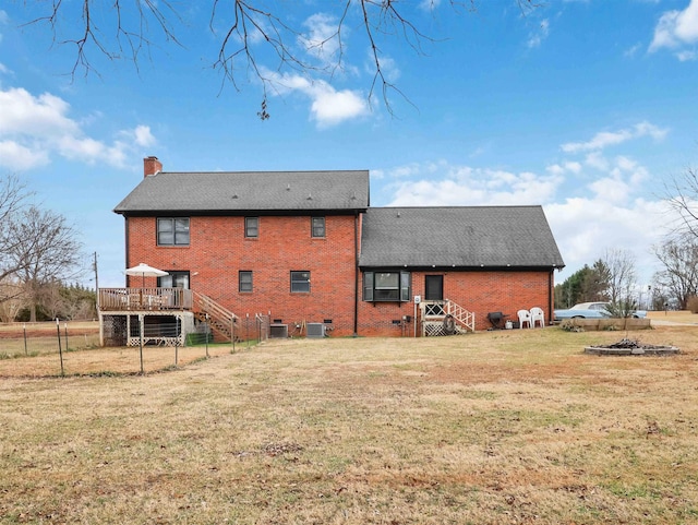 back of property with a yard, a deck, and central air condition unit