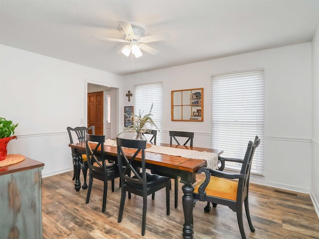 dining room with dark hardwood / wood-style flooring, a textured ceiling, and ceiling fan