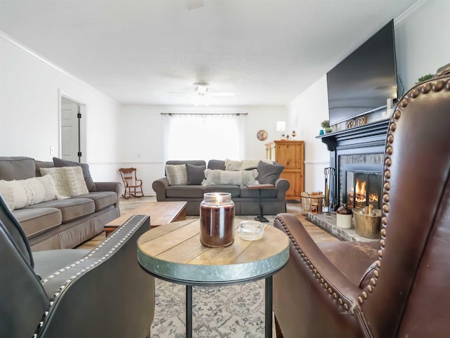 living room with ceiling fan, ornamental molding, and a brick fireplace