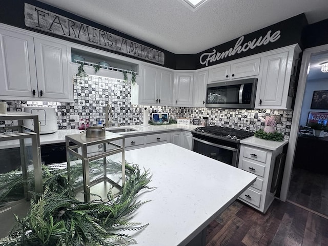 kitchen with white cabinetry, sink, backsplash, dark hardwood / wood-style flooring, and gas stove