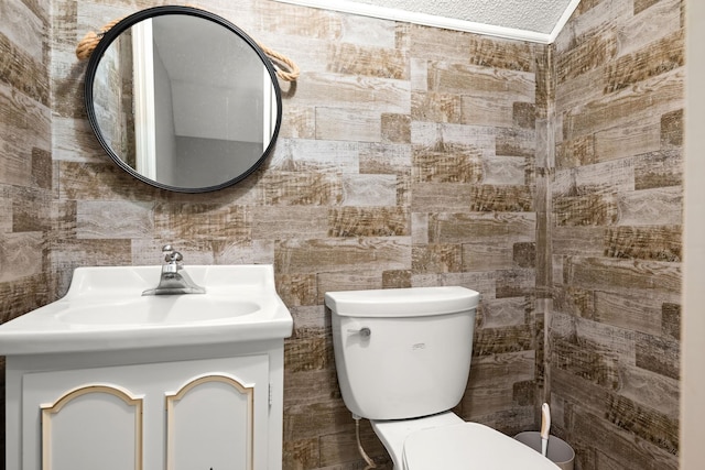 bathroom featuring vanity, tile walls, and toilet