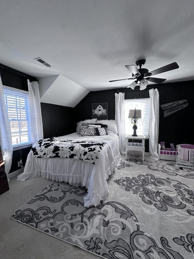 bedroom featuring ceiling fan, lofted ceiling, light colored carpet, and a textured ceiling