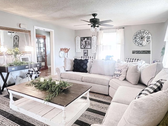 living room featuring ceiling fan, hardwood / wood-style floors, and a textured ceiling