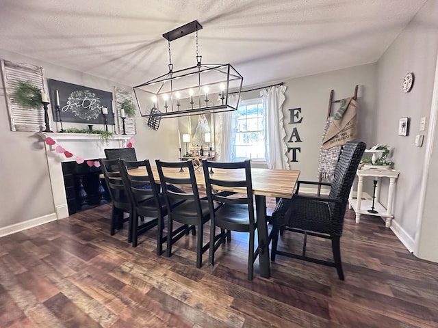 dining area with dark hardwood / wood-style floors, an inviting chandelier, and a textured ceiling