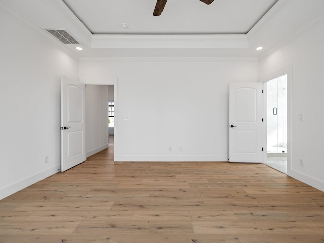 unfurnished room with crown molding, light hardwood / wood-style flooring, a raised ceiling, and ceiling fan