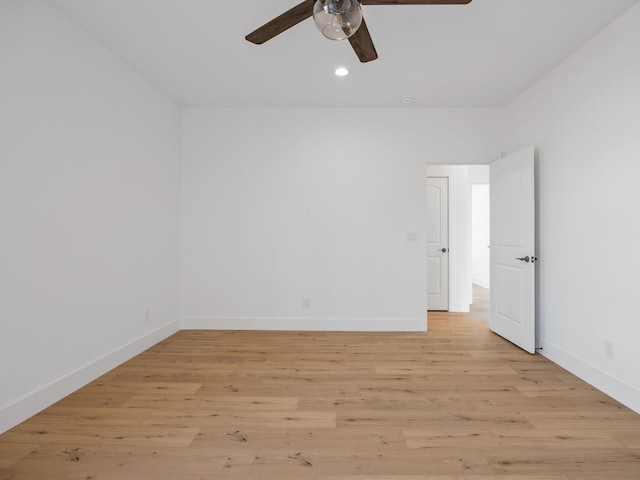 empty room with ceiling fan and light hardwood / wood-style flooring