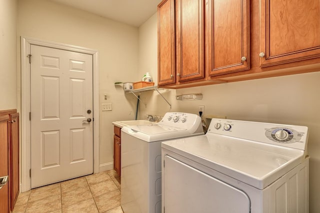 laundry room with cabinets, sink, washer and dryer, and light tile patterned floors