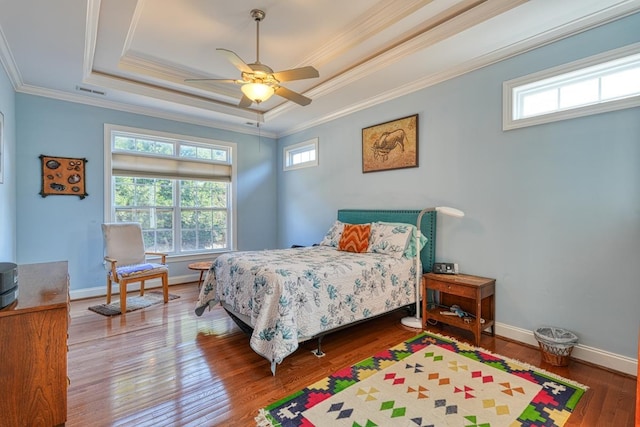 bedroom featuring hardwood / wood-style floors, ornamental molding, a raised ceiling, and ceiling fan