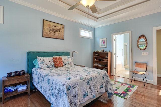 bedroom with wood-type flooring, ornamental molding, a raised ceiling, and ceiling fan