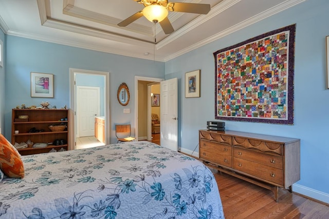 bedroom with a raised ceiling, crown molding, hardwood / wood-style floors, and ceiling fan