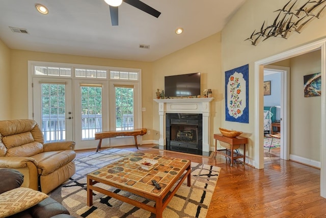 living room with french doors, ceiling fan, lofted ceiling, and light wood-type flooring