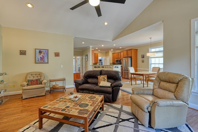 living room featuring high vaulted ceiling, crown molding, and light hardwood / wood-style floors