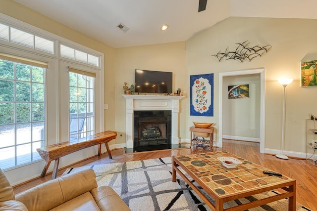 living room featuring lofted ceiling and light hardwood / wood-style flooring