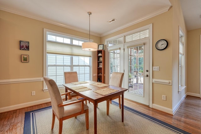 dining area with hardwood / wood-style floors and ornamental molding