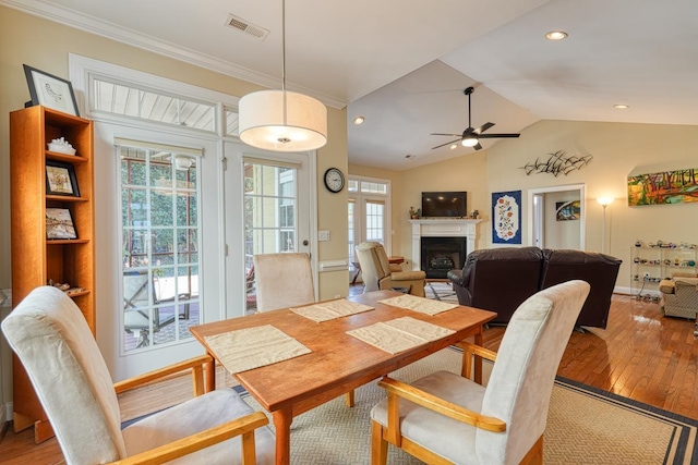 dining space featuring ceiling fan, a wealth of natural light, vaulted ceiling, and light wood-type flooring