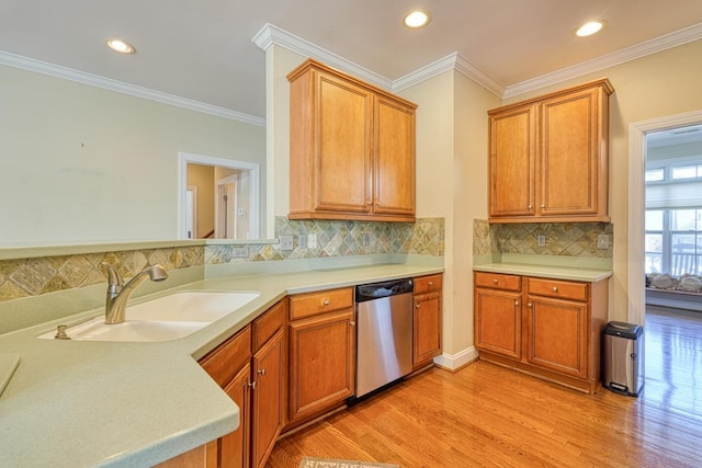 kitchen with dishwasher, sink, backsplash, ornamental molding, and light hardwood / wood-style flooring