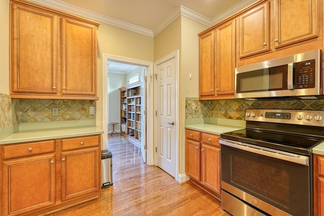 kitchen featuring tasteful backsplash, ornamental molding, light hardwood / wood-style floors, and appliances with stainless steel finishes