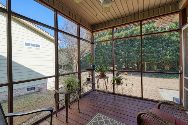 unfurnished sunroom with wood ceiling, ceiling fan, and a healthy amount of sunlight