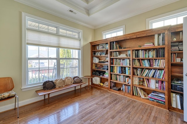 sitting room with ornamental molding and light wood-type flooring