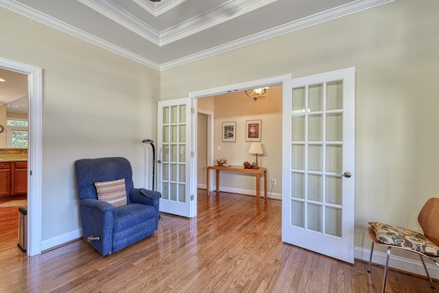 sitting room with ornamental molding, light hardwood / wood-style floors, and french doors