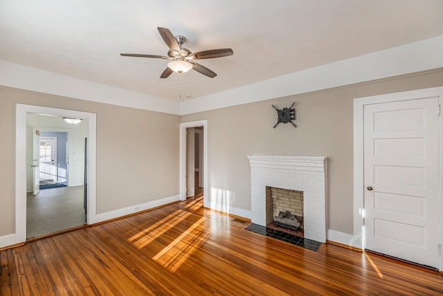 unfurnished living room featuring ceiling fan, hardwood / wood-style floors, and a fireplace