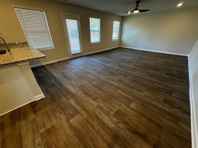 unfurnished dining area featuring ceiling fan and dark hardwood / wood-style flooring