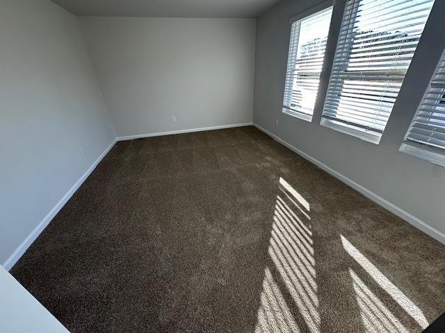 empty room featuring dark colored carpet